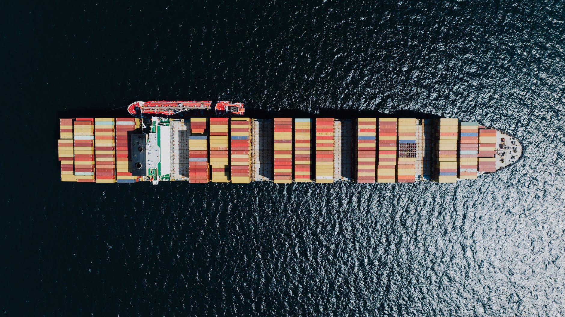 directly above a fully loaded cargo ship on a sea